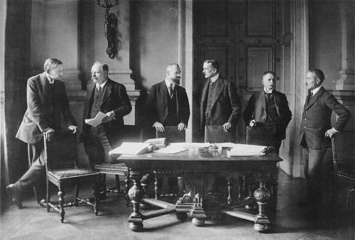 German delegates in Versailles 1919: Professor Walther Schücking, Reichspostminister Johannes Giesberts, Justice Minister Otto Landsberg, Foreign Minister Ulrich Graf von Brockdorff-Rantzau, Prussian State President Robert Leinert, and financial advisor Carl Melchior By Bundesarchiv, Bild 183-R01213 / CC-BY-SA 3.0, CC BY-SA 3.0 de, https://commons.wikimedia.org/w/index.php?curid=5436001